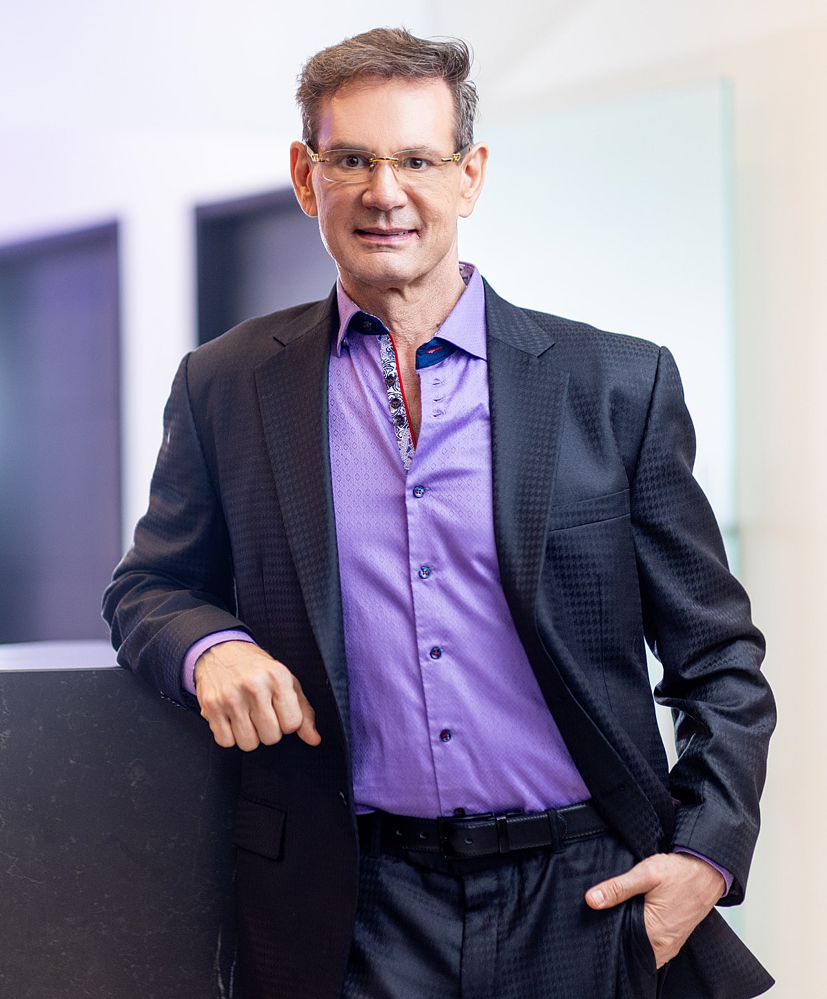 Newport Beach plastic surgeon in formal attire, posing confidently indoors.