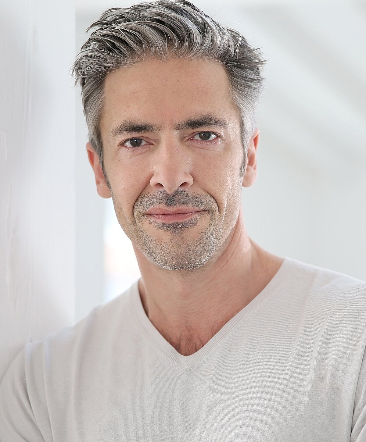 Orange County neck lift model with gray hair in a light shirt.