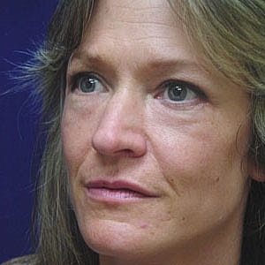 Side profile of a woman against blue background.