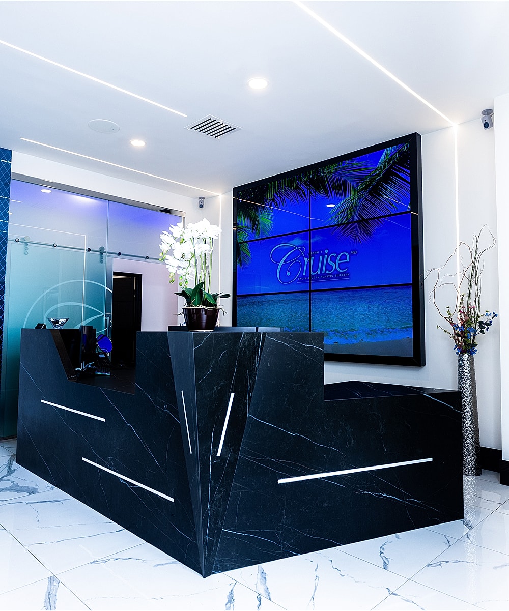 Orange County plastic surgery reception area with stylish black desk.