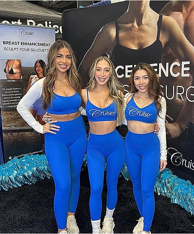 Three women in blue athletic apparel at event.