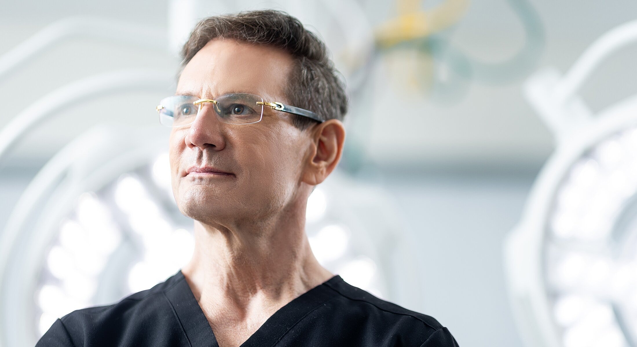 Orange County Rhinoplasty Surgeon in surgical scrubs, serious expression.